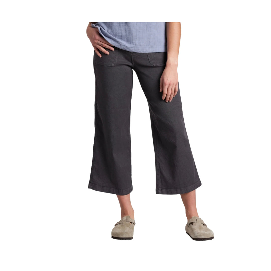 Person wearing dark gray capri pants on a white background