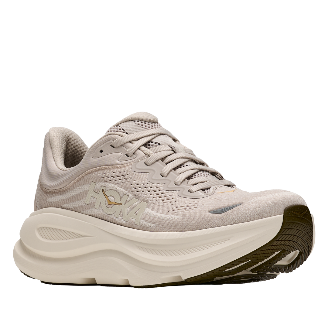 Beige running shoe with a white sole on a white background