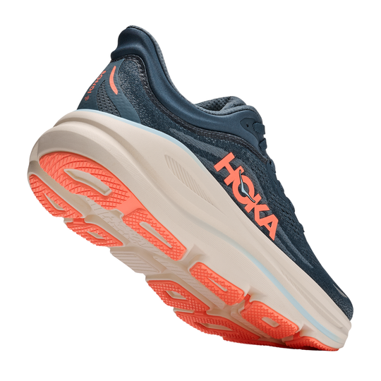Navy running shoe with orange sole on a white background