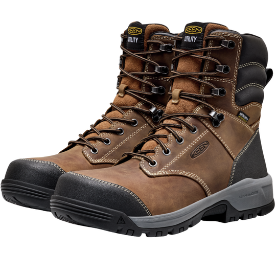 Pair of brown work boots with black soles on a white background