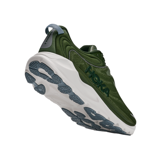 Green running shoe with white sole on a white background