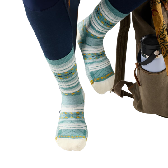 Patterned socks worn with a backpack on a white background
