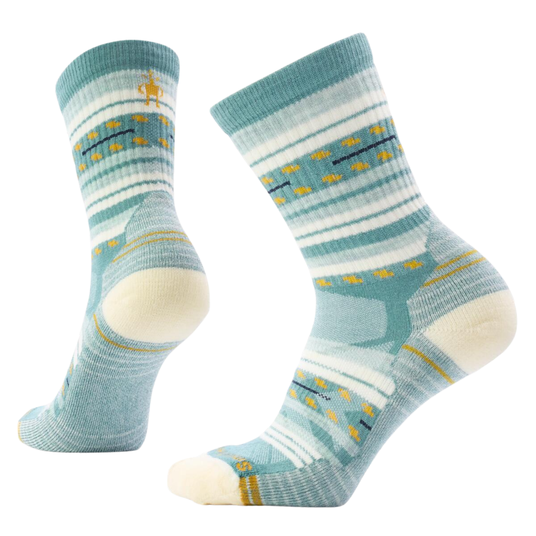 Pair of dusty teal socks with white and yellow patterns on a white background