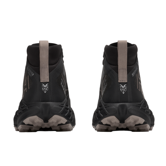 Black hiking boots with brown straps on a white background