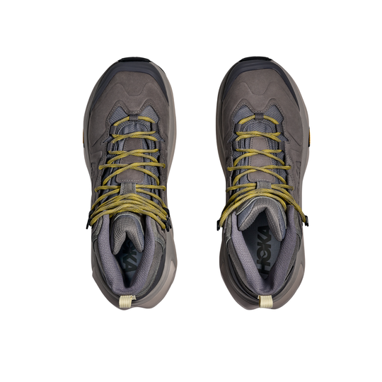 Pair of gray hiking boots with yellow laces on a white background