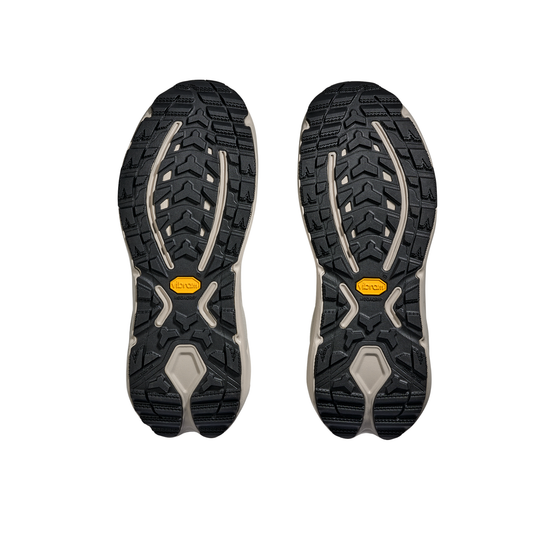 Black and gray sole of a shoe with a yellow label on a white background