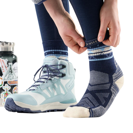 Person wearing blue hiking socks with a water bottle and snacks in the background