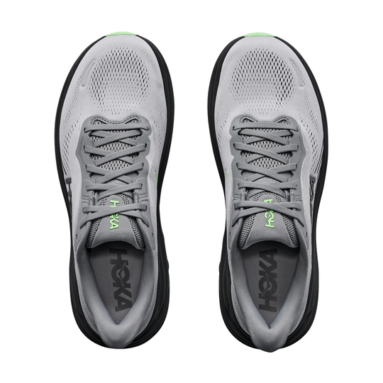 Gray running shoes with black soles and green accents on a white background