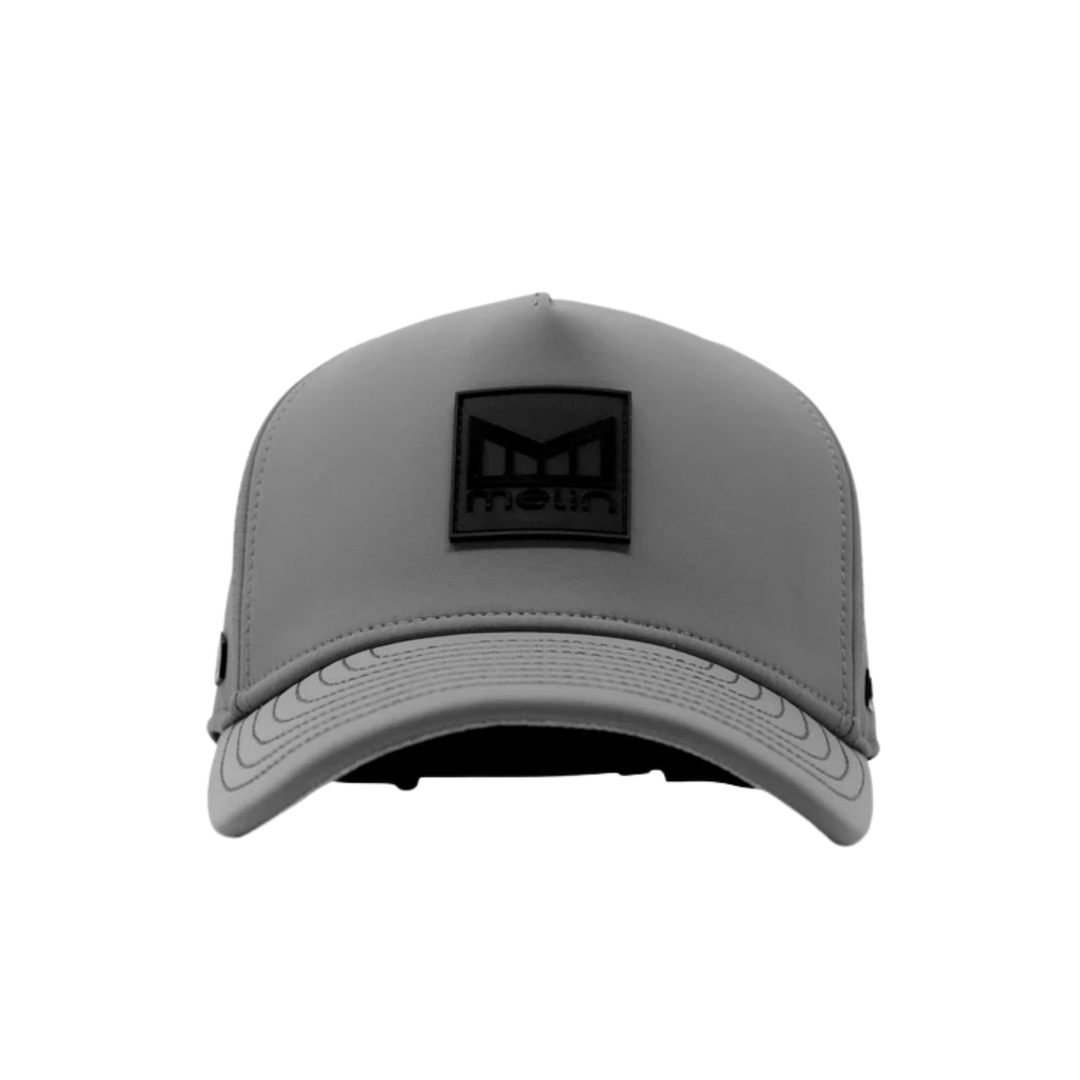 A gray trucker-style cap with a black rectangular patch on the front featuring a stylized 'M' logo and the word 'MELIN'.