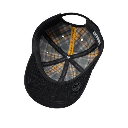 Black trucker-style baseball cap shown from an overhead angle, featuring a black brim, black mesh back, and a gray and yellow plaid patterned interior.