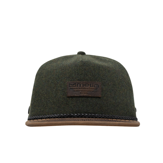 An olive green felt flat-brim cap with a brown leather patch on the front reading 'im melin', a braided black rope detail along the brim, and a brown leather brim.