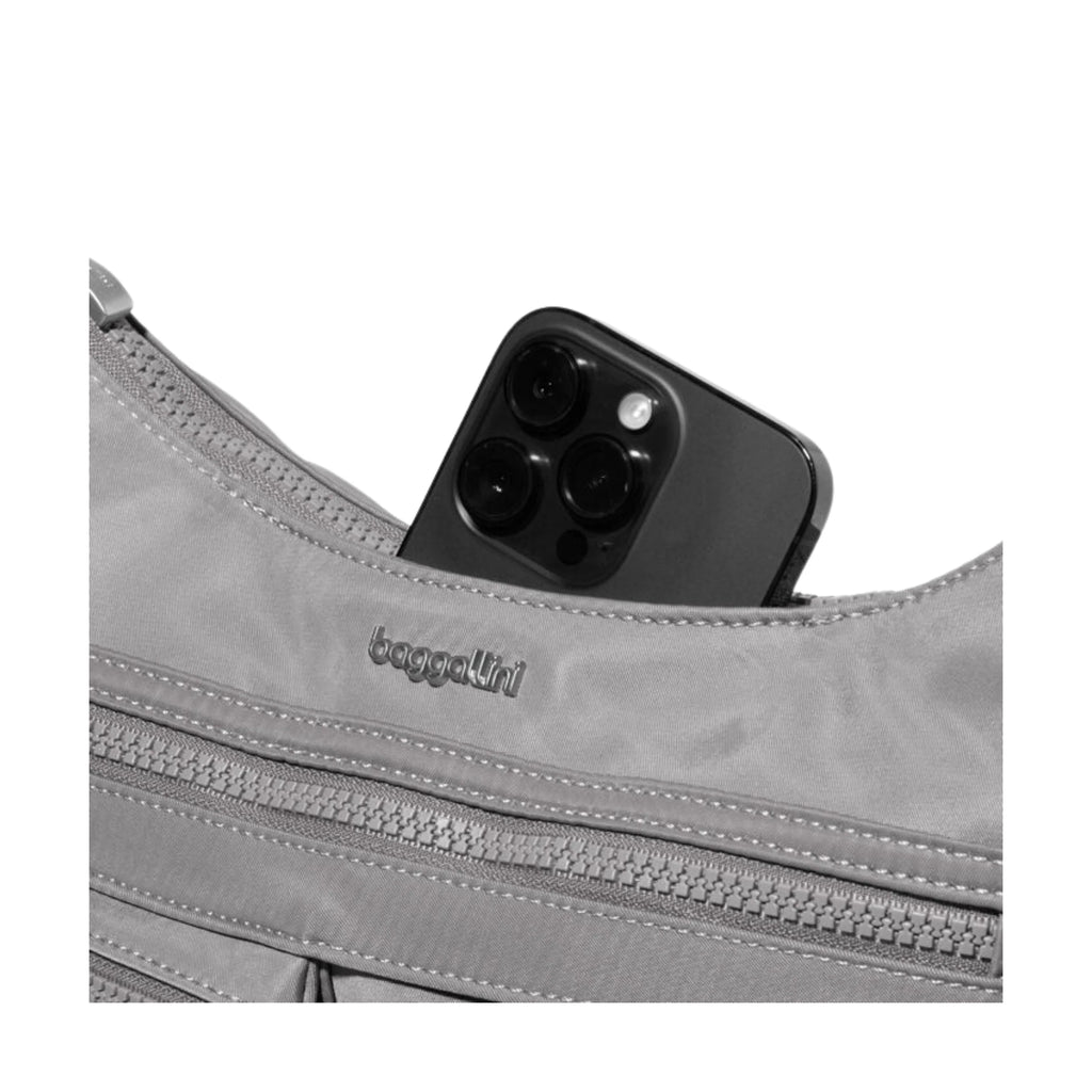 Gray bag with a phone inside, featuring the brand 'baggallini'.