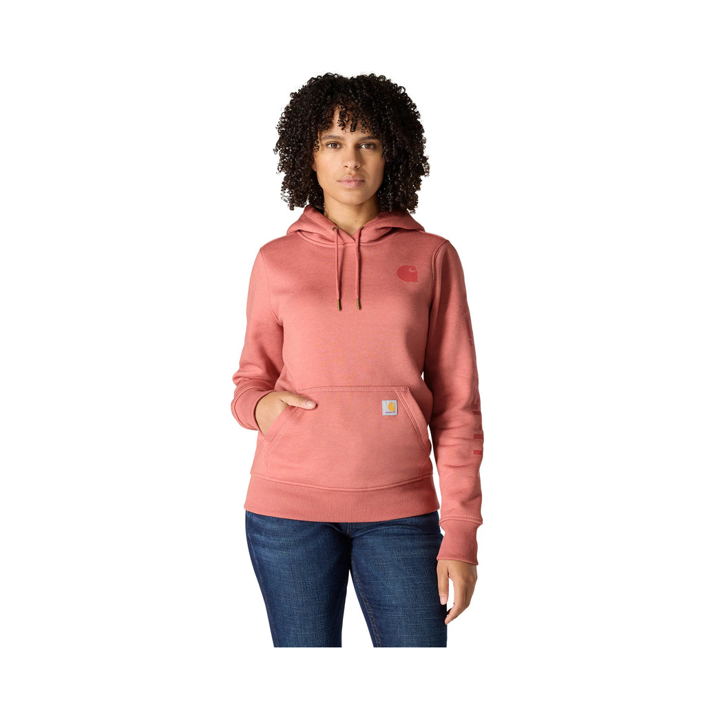 Person wearing a pink hoodie with a brand logo on a white background