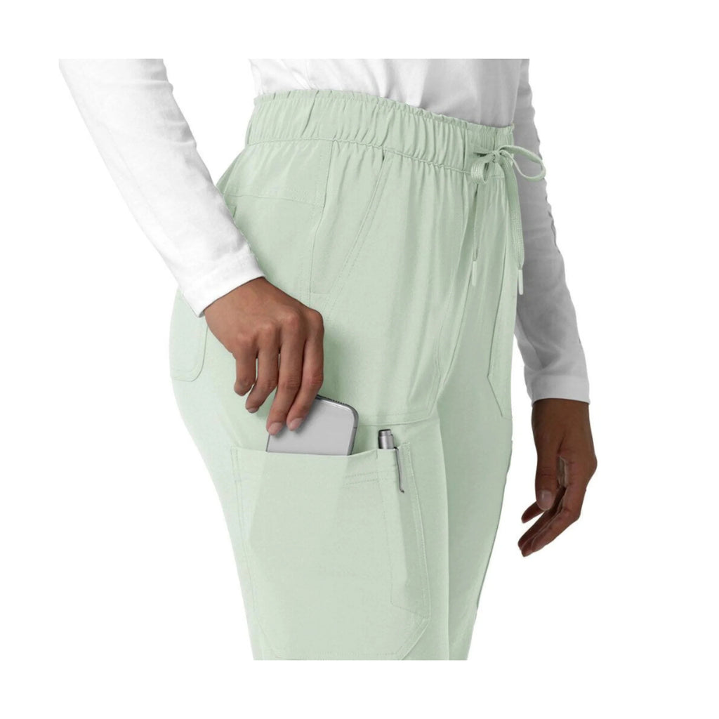 Light green scrubs with pockets on a white background