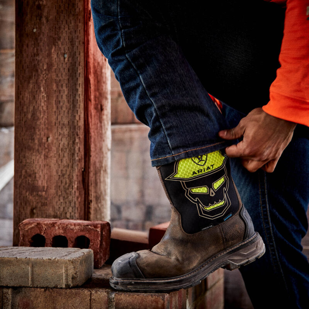 Person wearing a boot with a visible brand logo on a construction site.