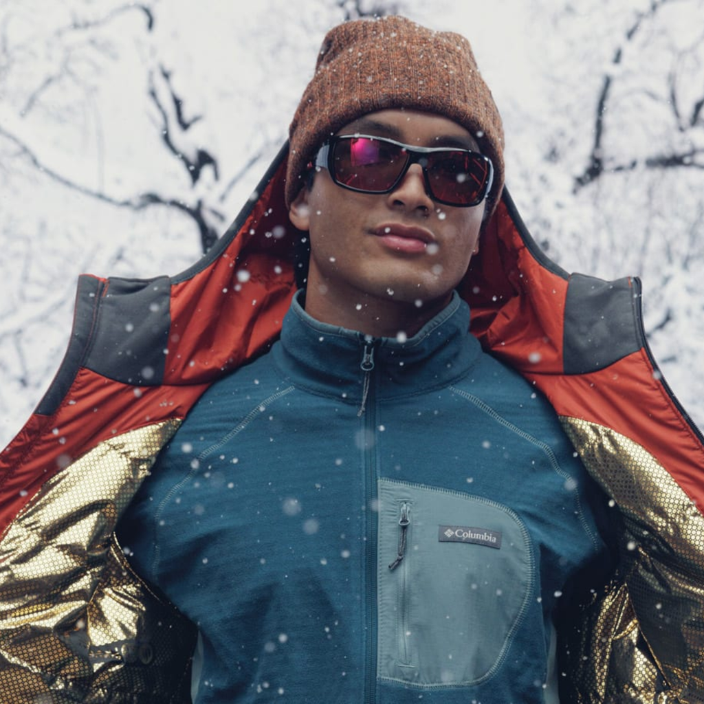 Person wearing a blue jacket with Columbia logo in a snowy setting