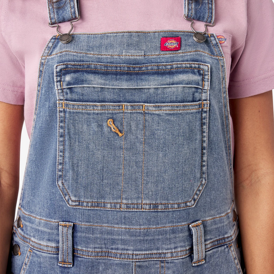 Dickies Women's Double Front Bib Overalls - Light Stonewash on a female model on a white background. Close up of chest pocket.