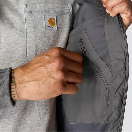 Carhartt Men's Gilliam Active Jacket - Shadow on a male model on a white background. Zoomed into interior zip pocket.
