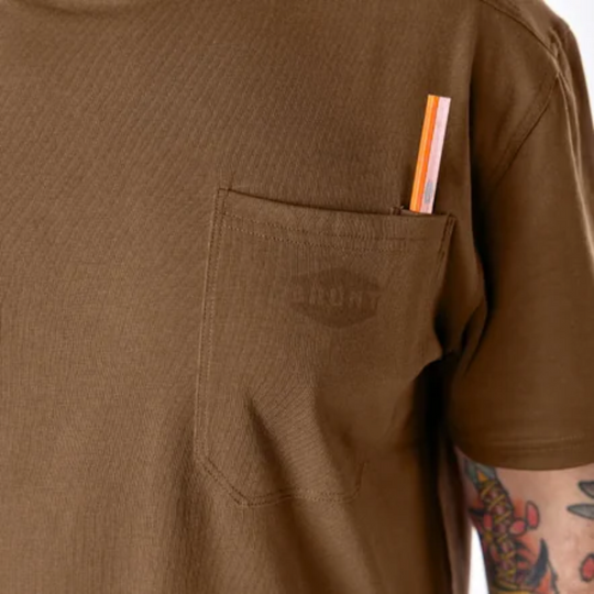 Brunt Men's The Martin Pocket Tee - Mud Brown on a male model on a white background. Zoomed in on pocket with Brunt logo.