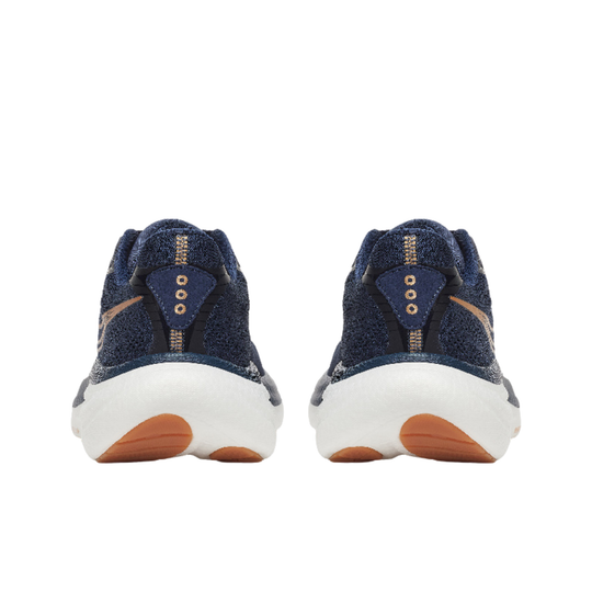Pair of navy blue sneakers with white soles and brown accents on a white background