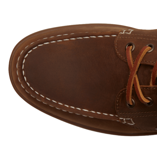Close-up of toe box of a brown shoe on a white background