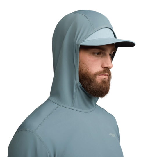 Man wearing a light blue hooded jacket and cap on a white background