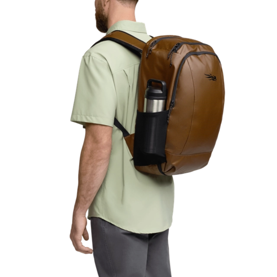 Man wearing a brown backpack with a water bottle holder on a white background