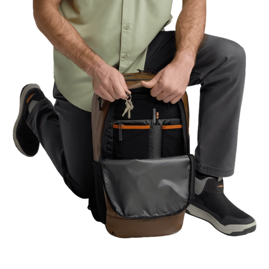 Person opening a backpack with multiple compartments on a white background