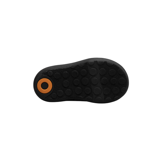 Black shoe sole with a brown circular feature on a white background