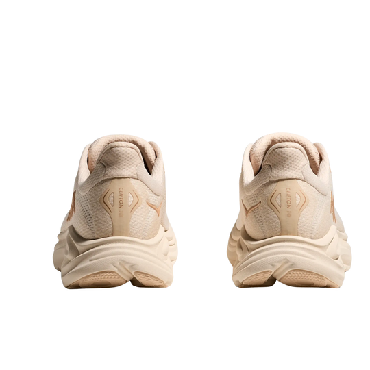 Pair of beige running shoes shown from the back on a white background