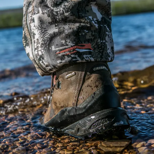 Person wearing a camouflage pant and boot in water