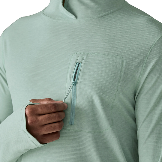 Light green pullover with a hand reaching into a pocket