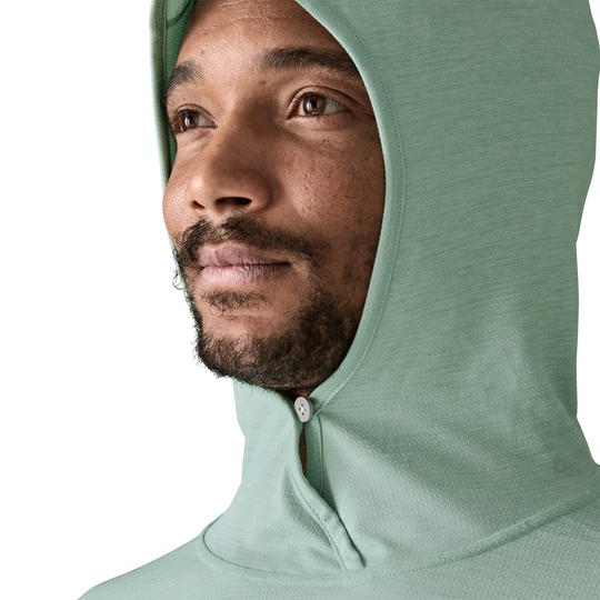 Person wearing a light green hoodie with a white background