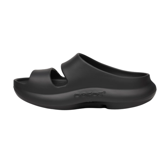 A single black OOfos slide sandal shown from a side profile view against a plain white background.