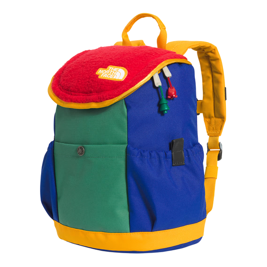 A multicolor backpack by The North Face, featuring a color-blocked design with royal blue, green, and yellow panels, a red fleece top flap, and yellow straps, shown on a white background.