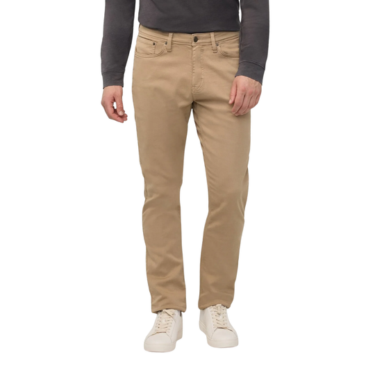 A person wearing slim-fit tan chinos with a dark gray long-sleeve shirt and white sneakers, shown from the waist down on a plain white background.