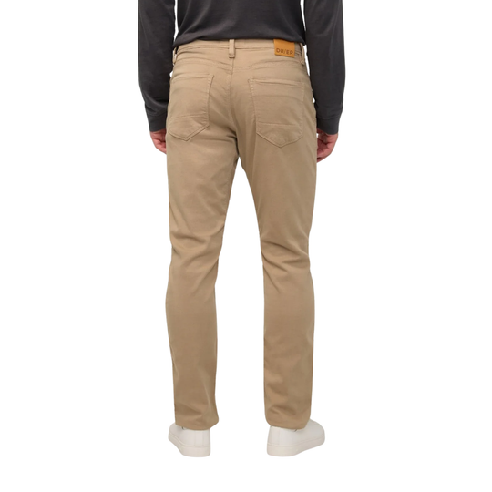 A person shown from the back wearing beige straight-leg chinos with a black long-sleeve shirt and white sneakers, photographed against a plain white background.