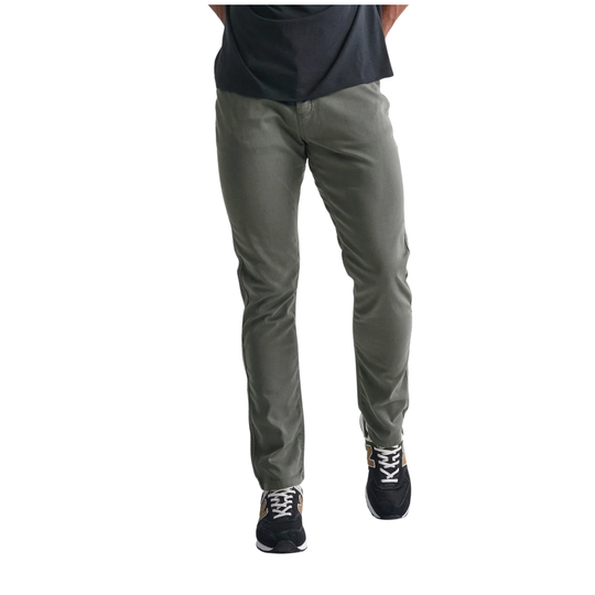 A person wearing slim-fit grey pants, a dark navy t-shirt, and black sneakers with white laces, shown from the waist down against a plain white background.