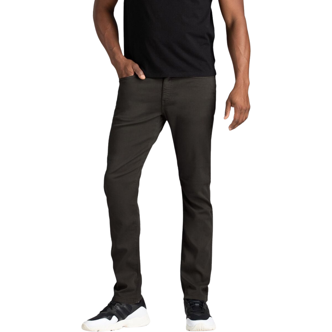A man wearing slim-fit dark charcoal gray pants, a black t-shirt, and black and white sneakers, shown from the waist down against a plain white background.
