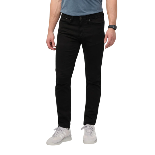 A person wearing slim-fit black jeans, a light blue t-shirt, and white sneakers, shown from the waist down against a plain white background.