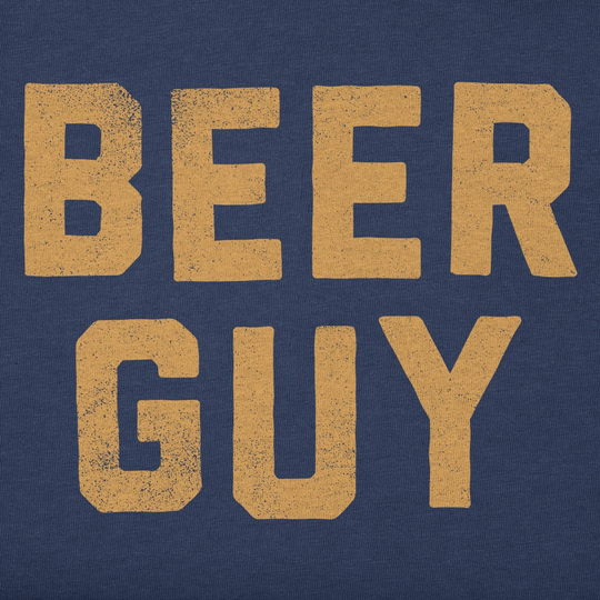 A close-up of a navy blue fabric surface with large distressed tan text reading “BEER GUY.”