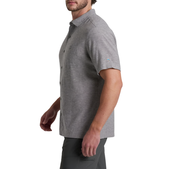 A man wearing a heather gray short-sleeve button-up shirt, shown in a side profile against a plain white background.