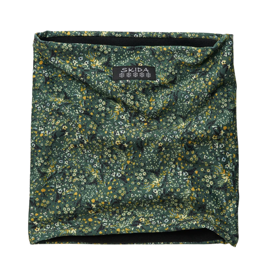A dark green neck gaiter with a dense yellow, white, and black floral pattern, featuring a black brand label that reads 'SKIDA' at the top center.