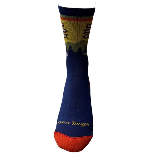 A single crew sock with a navy blue body, a yellow and green mountain landscape graphic on the upper section, and 'Darn Tough' written in yellow on the toe cap, set against a plain white background.