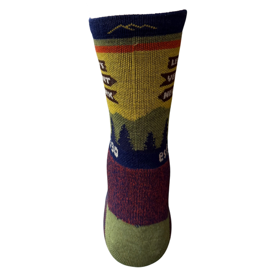 A single crew sock with a colorful mountain and tree pattern, featuring a yellow and green sunset design, dark blue sections, and a green toe and heel.