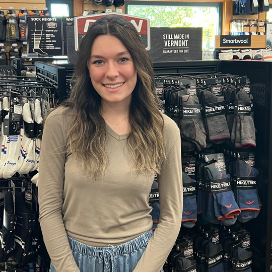 female employee standing in front of Darn Tough Vermont socks