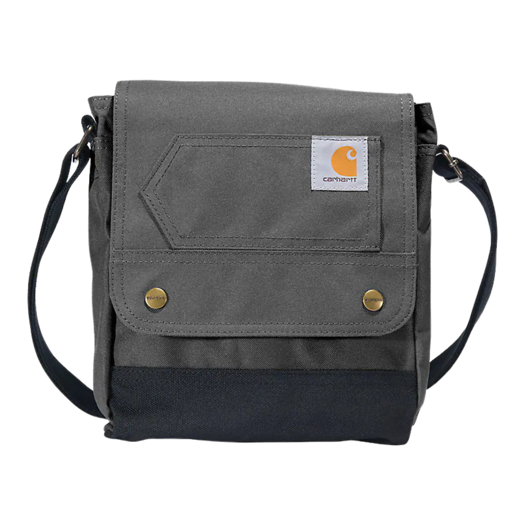 A gray and black Carhartt crossbody bag with a front flap pocket, brass snap buttons, and a white Carhartt logo patch, shown on a plain white background.