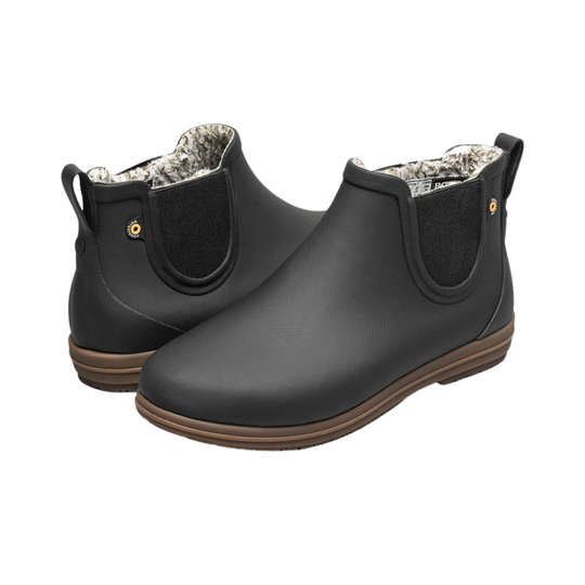 Pair of black rubber boots with brown soles on a white background