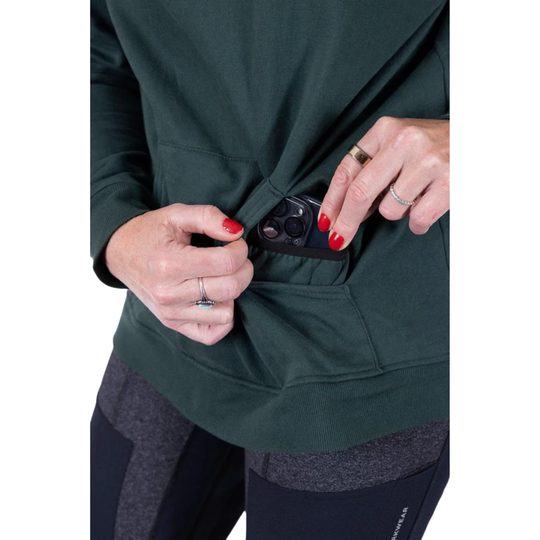 Person opening a green jacket pocket with a phone inside on a white background