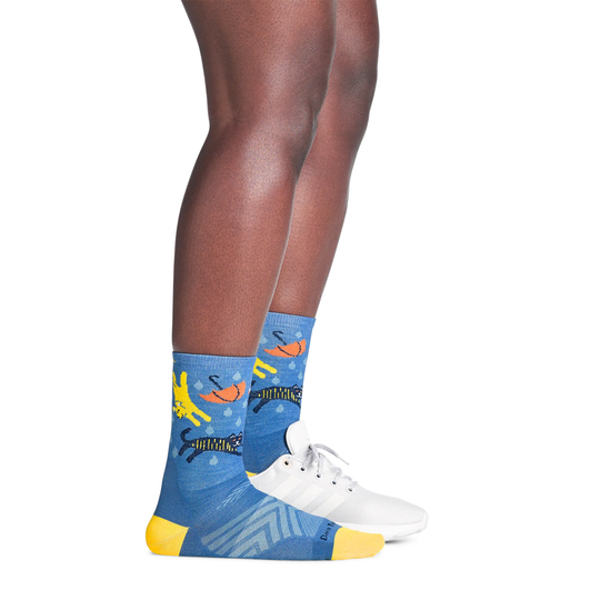 Blue socks with colorful designs worn by a person on a white background